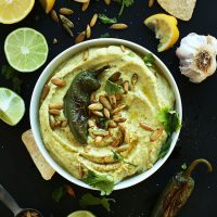 Bowl of homemade Jalapeno Hummus topped with a roasted jalapeno and pumpkin seeds