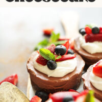 No-bake vegan and gluten-free chocolate cheesecakes topped with coconut whipped cream and fresh berries