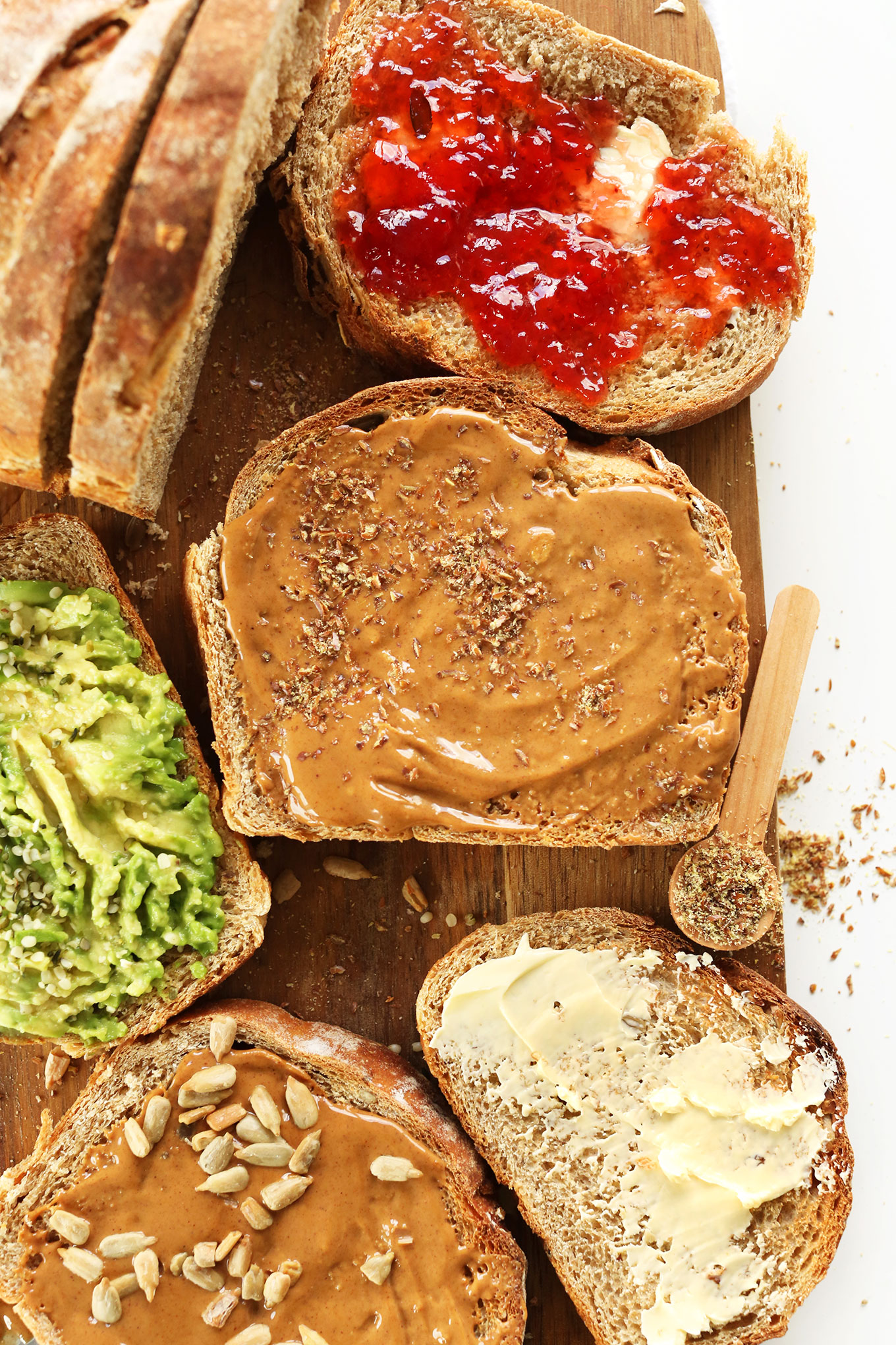Slices of simple homemade Whole Grain Seedy Vegan Bread with various toppings