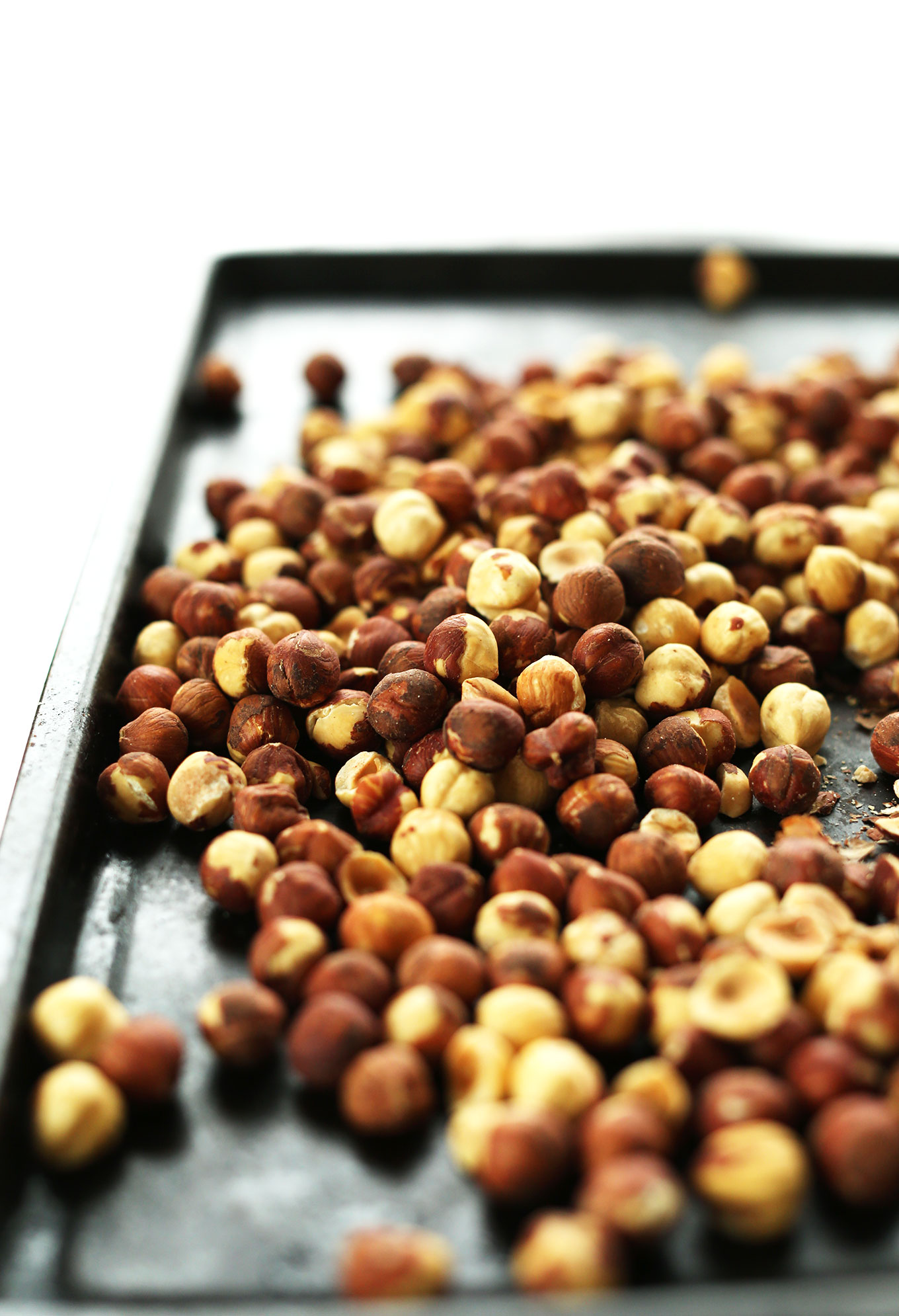 Roasting hazelnuts on a baking sheet for making homemade healthy nutella
