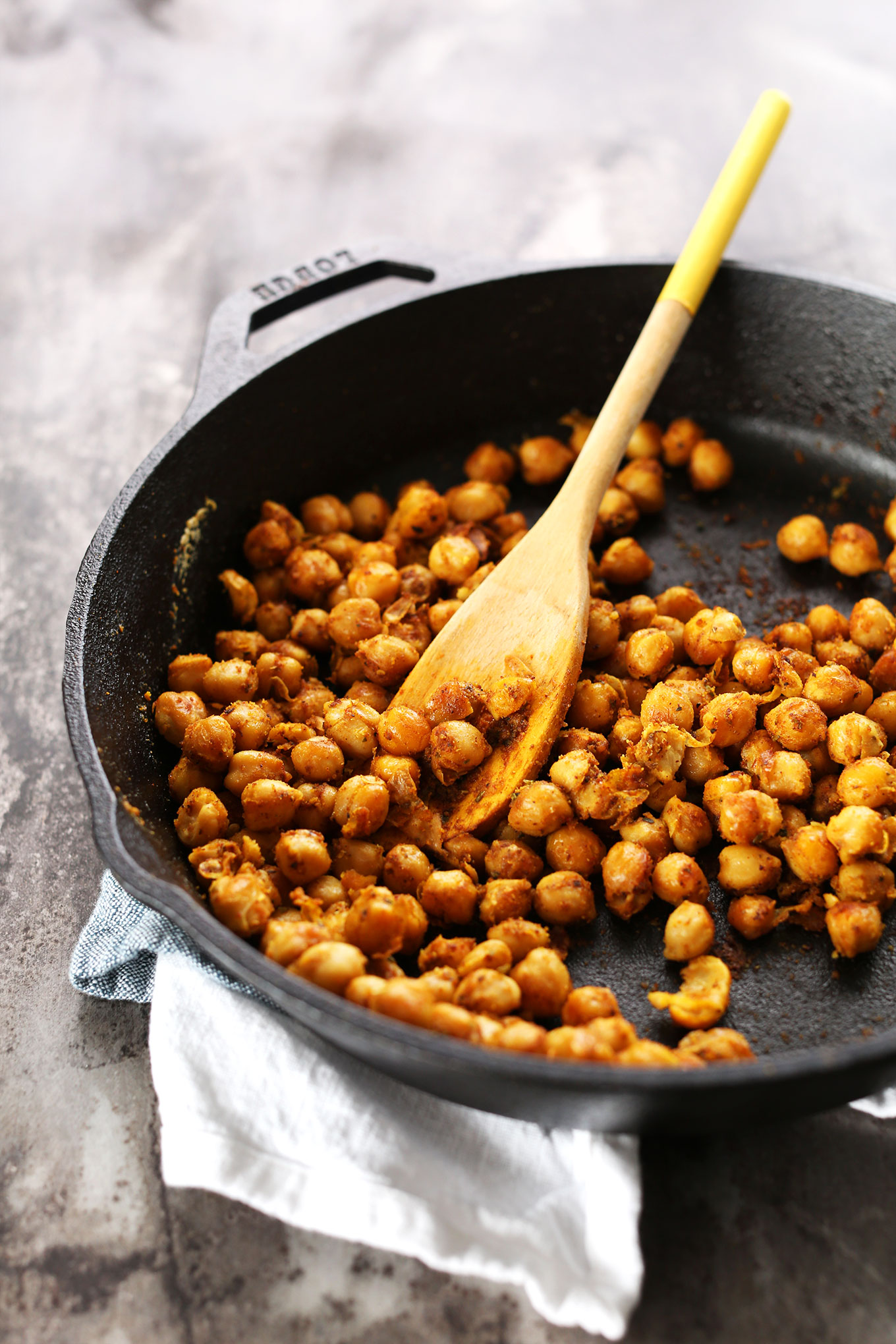 Cooking chickpeas in a cast-iron skillet for healthy Sweet Potato Chickpea Buddha Bowls