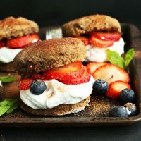 Baking sheet of Vegan Double Chocolate Shortcakes stuffed with coconut whip and fresh berries