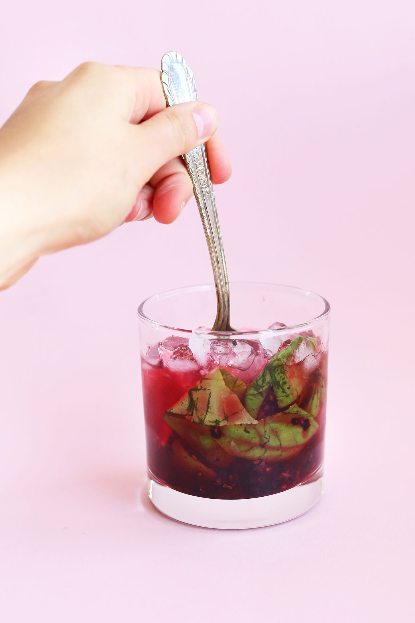 Stirring a Blackberry Basil Mojito for a refreshing summer drink