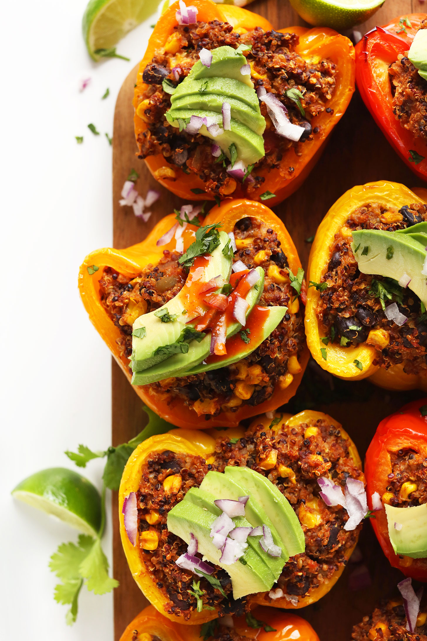 Close up shot of our Spanish Quinoa Stuffed Peppers recipe with sliced avocados and red onion