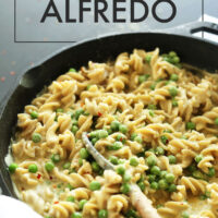 Cast iron skillet of 30-minute vegan and gluten-free Alfredo with a spoon in it