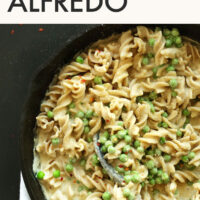Cast iron skillet of 30-minute vegan and gluten-free Alfredo with a spoon in it