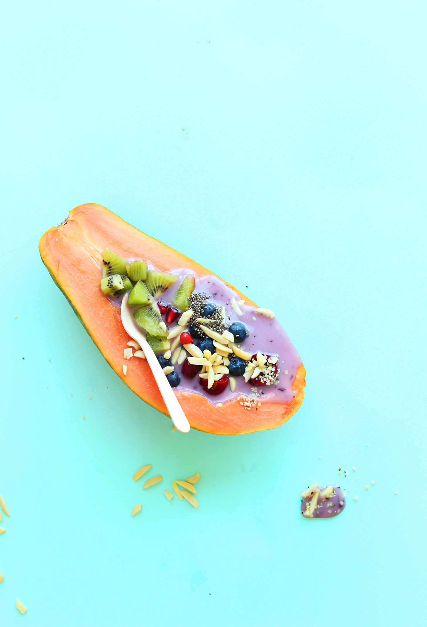 Using a spoon to eat a refreshing Papaya Boat for a simple gluten-free vegan breakfast