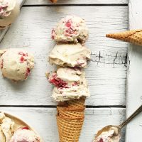 Stack of cones topped with scoops of homemade Raspberry Ripple Coconut Ice Cream