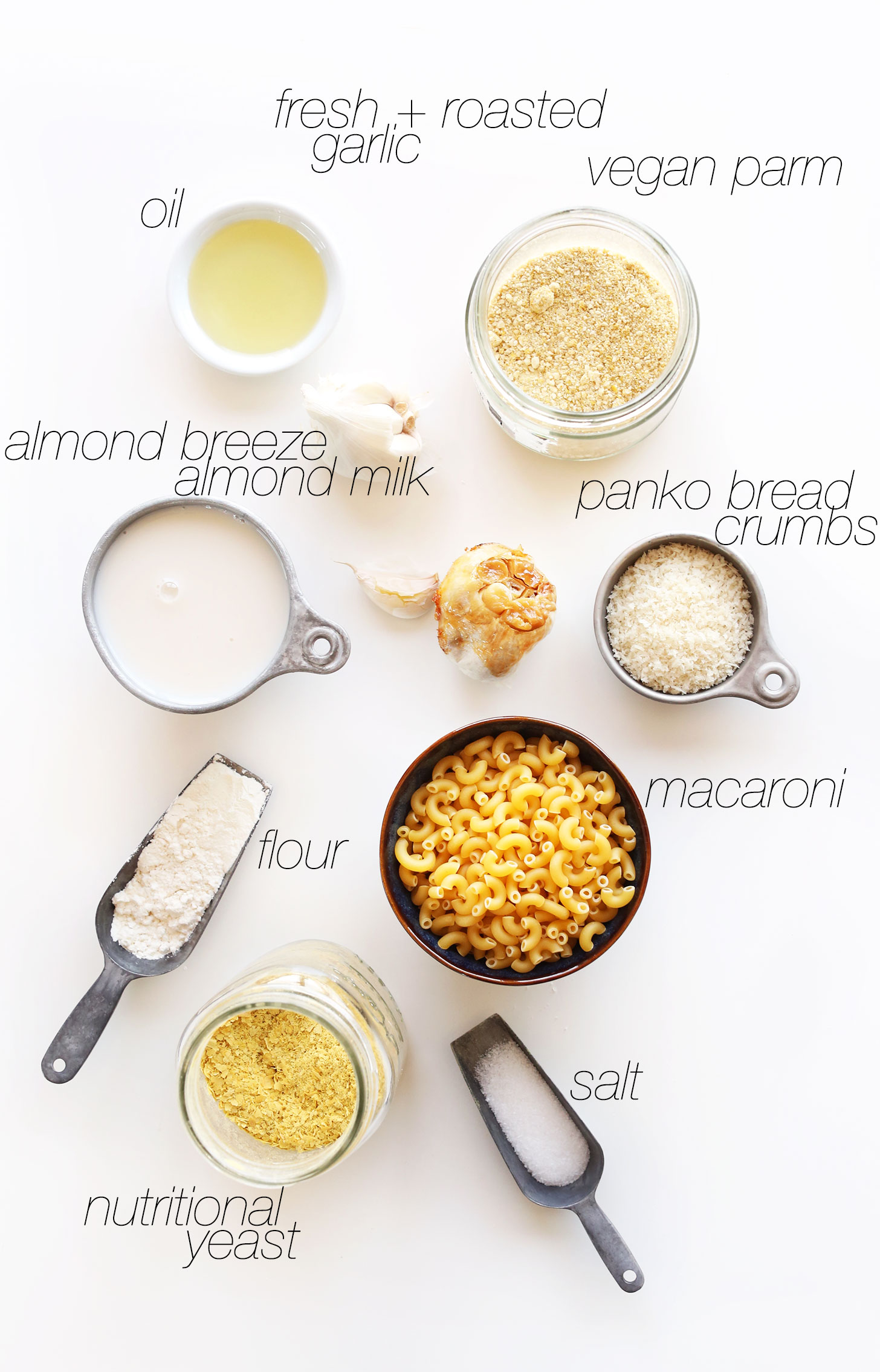 Nutritional yeast, salt, macaroni, breadcrumbs, vegan parm, garlic oil, almond milk, and flour for making Garlic Mac n Cheese