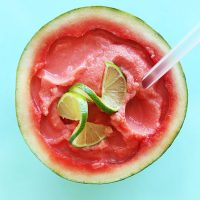 Homemade Watermelon Slushie served in a watermelon rind with fresh limes on top