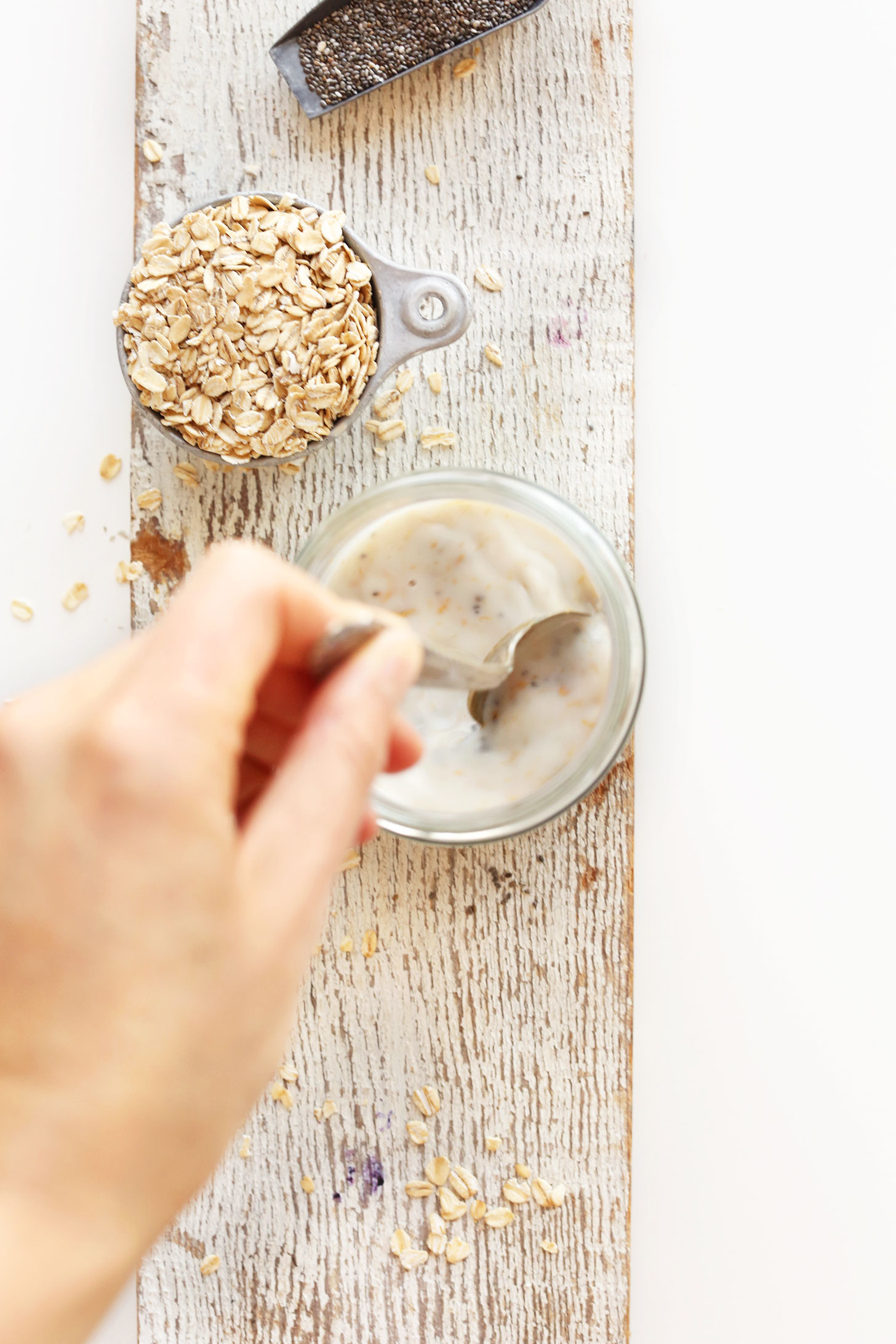 Stirring together a jar of Peanut Butter Overnight Oats for a healthy gluten-free vegan breakfast