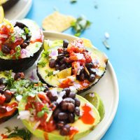 Plate of avocado boats stuffed with black beans, salsa, and red onion