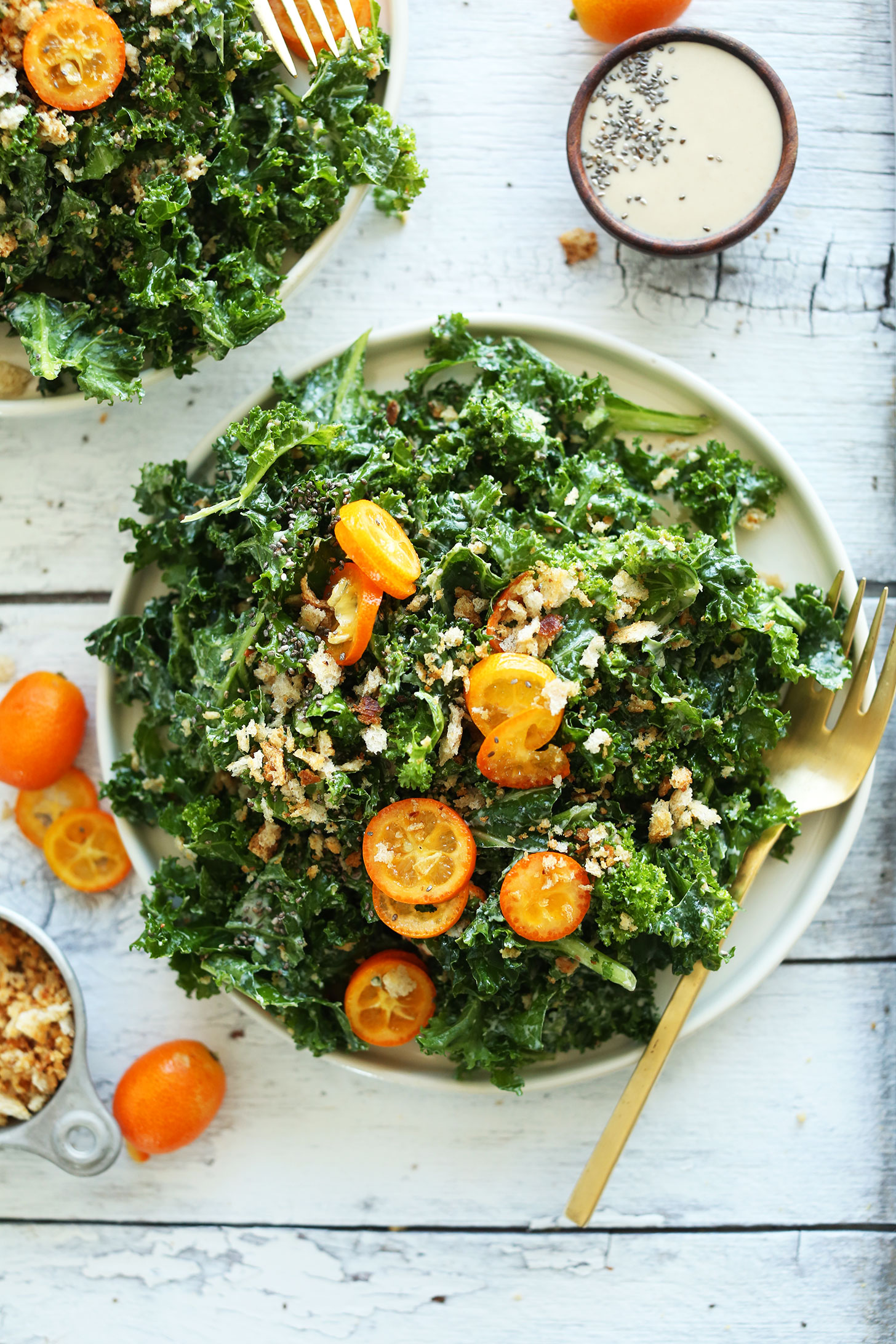 Dinner plate filled with our healthy and simple Kale Salad with Kumquats, Chia Seeds, and Tahini Dressing