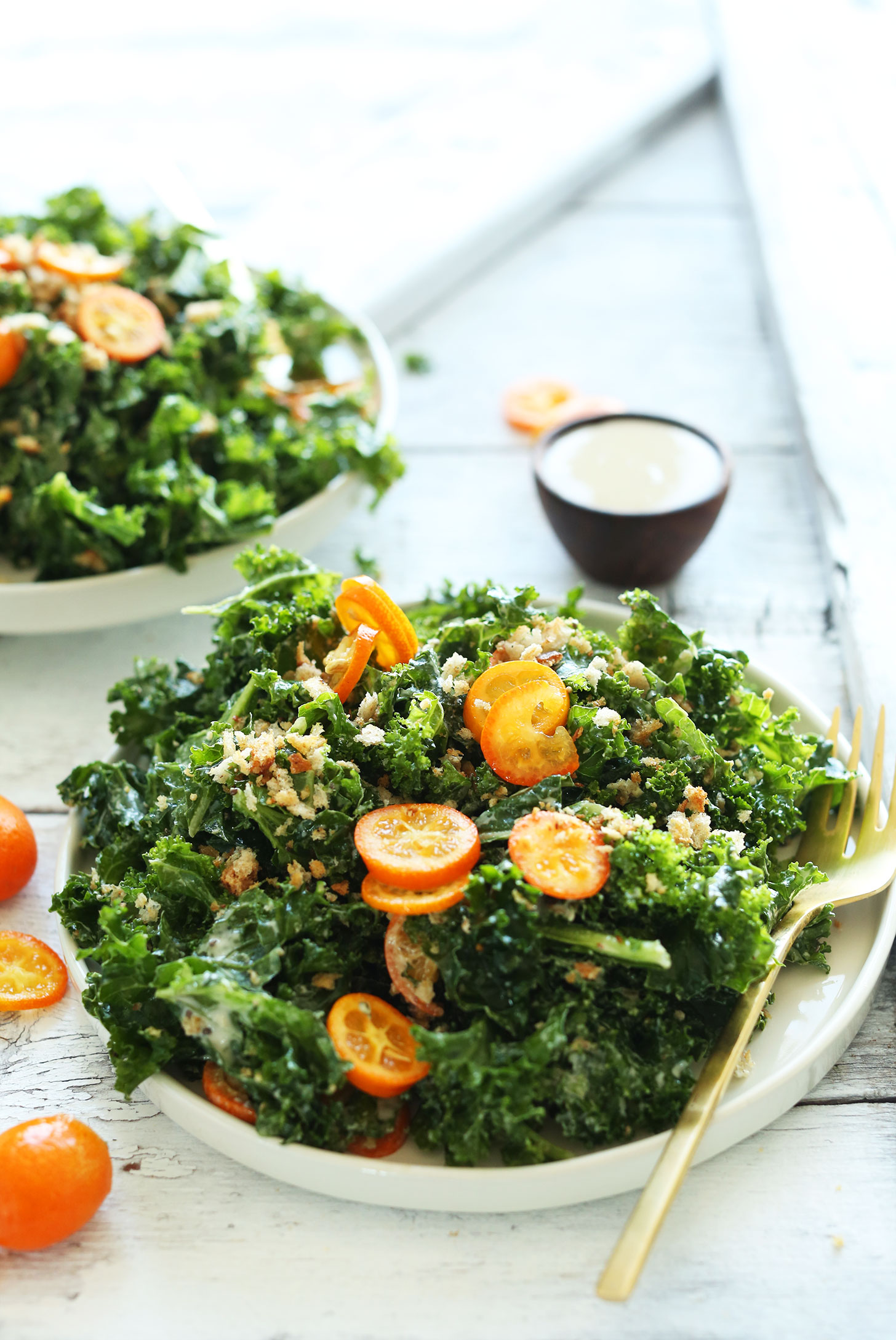 Big plate of our healthy and delicious vegan Kale Salad with Kumquats, Chia Seeds, and Tahini Dressing