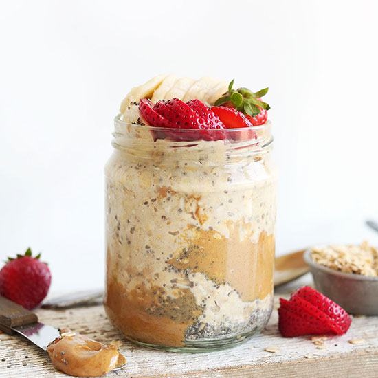 Jar of Peanut Butter Overnight Oats topped with sliced banana and strawberries
