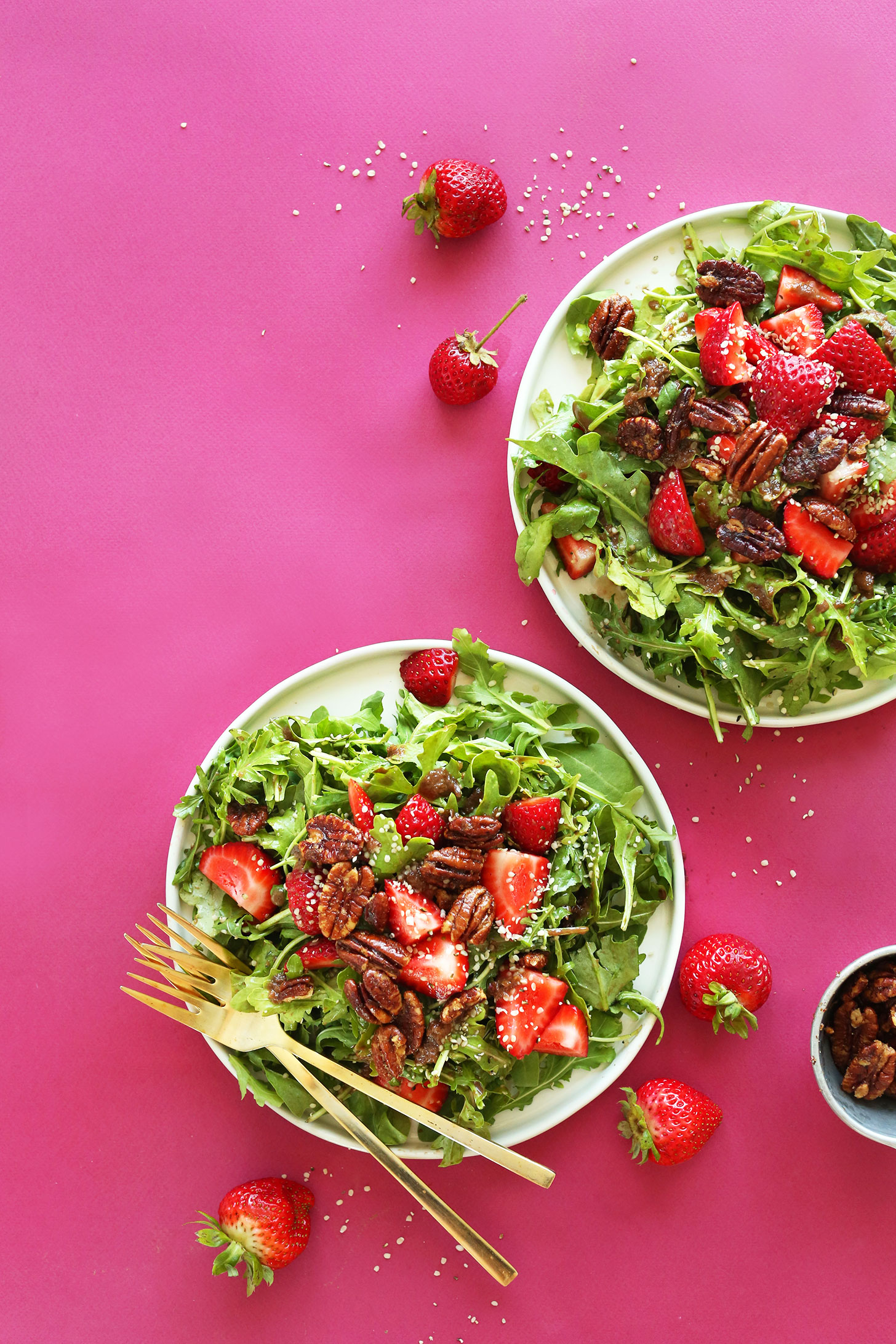 Dinner plates filled with our delicious recipe of Strawberry Arugula Salad with Hemp Seeds and Brown Sugar Pecans