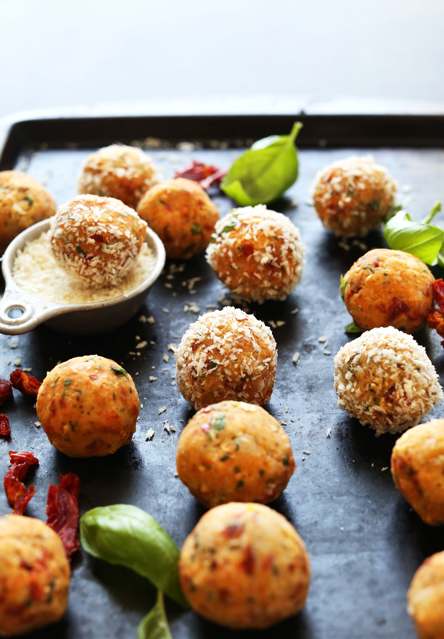 Baking sheet filled with a batch of our vegan Chickpea Meatballs with Sun-Dried Tomatoes and Basil