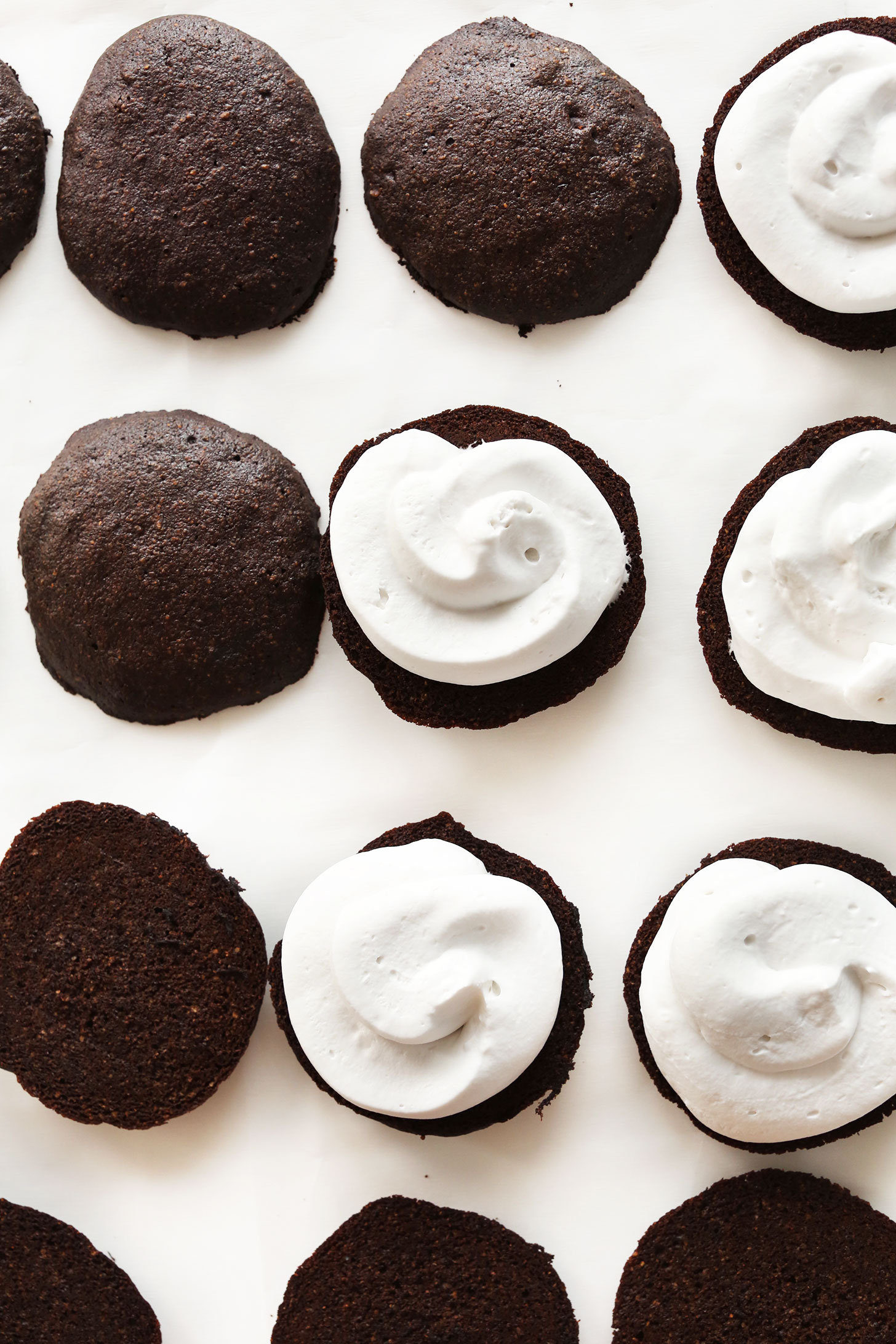 A batch of open-faced Vegan Whoopie Pies on parchment paper