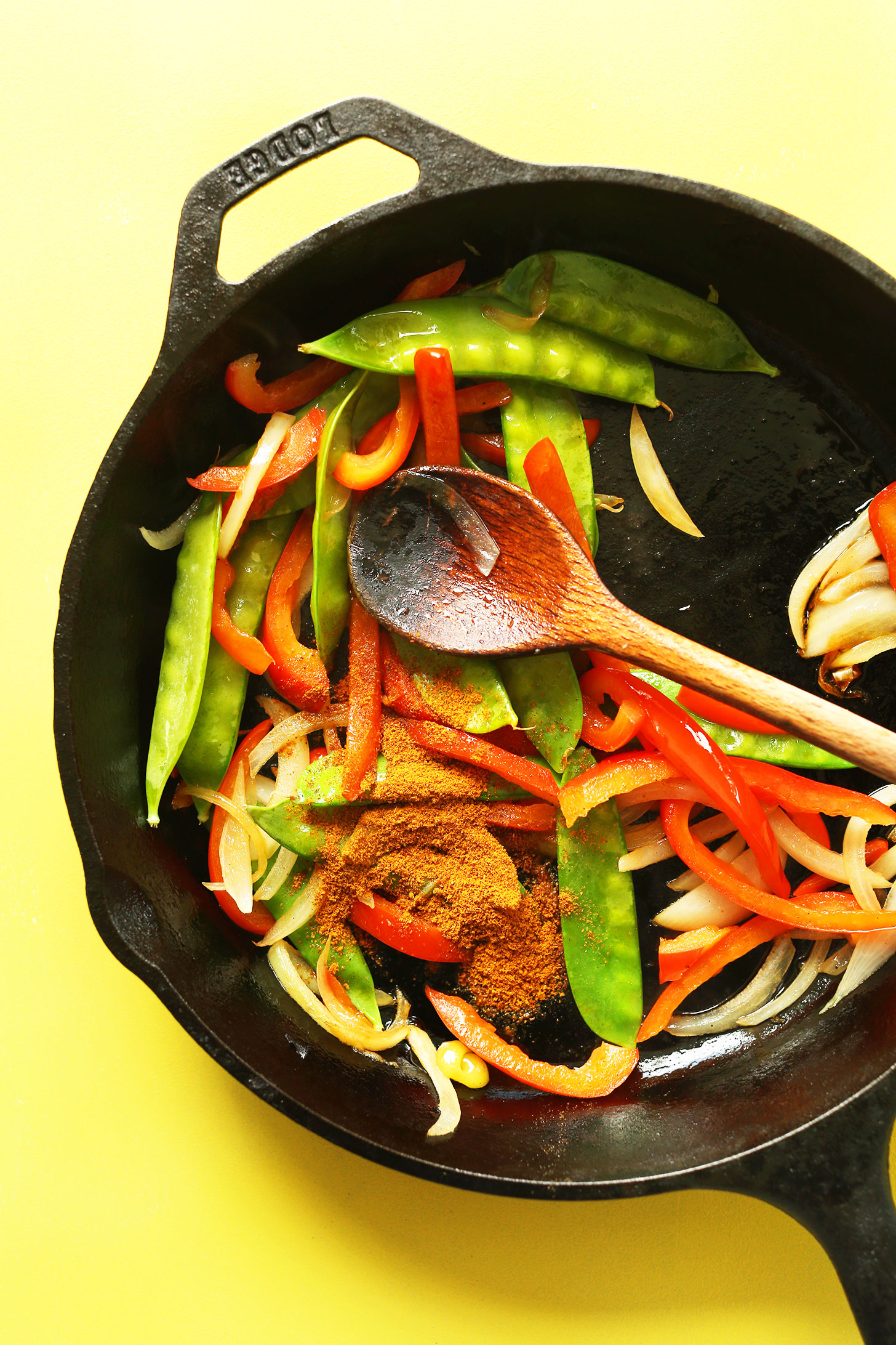 Cast-iron skillet with spices and vegetables for making Vegan Singapore Noodles