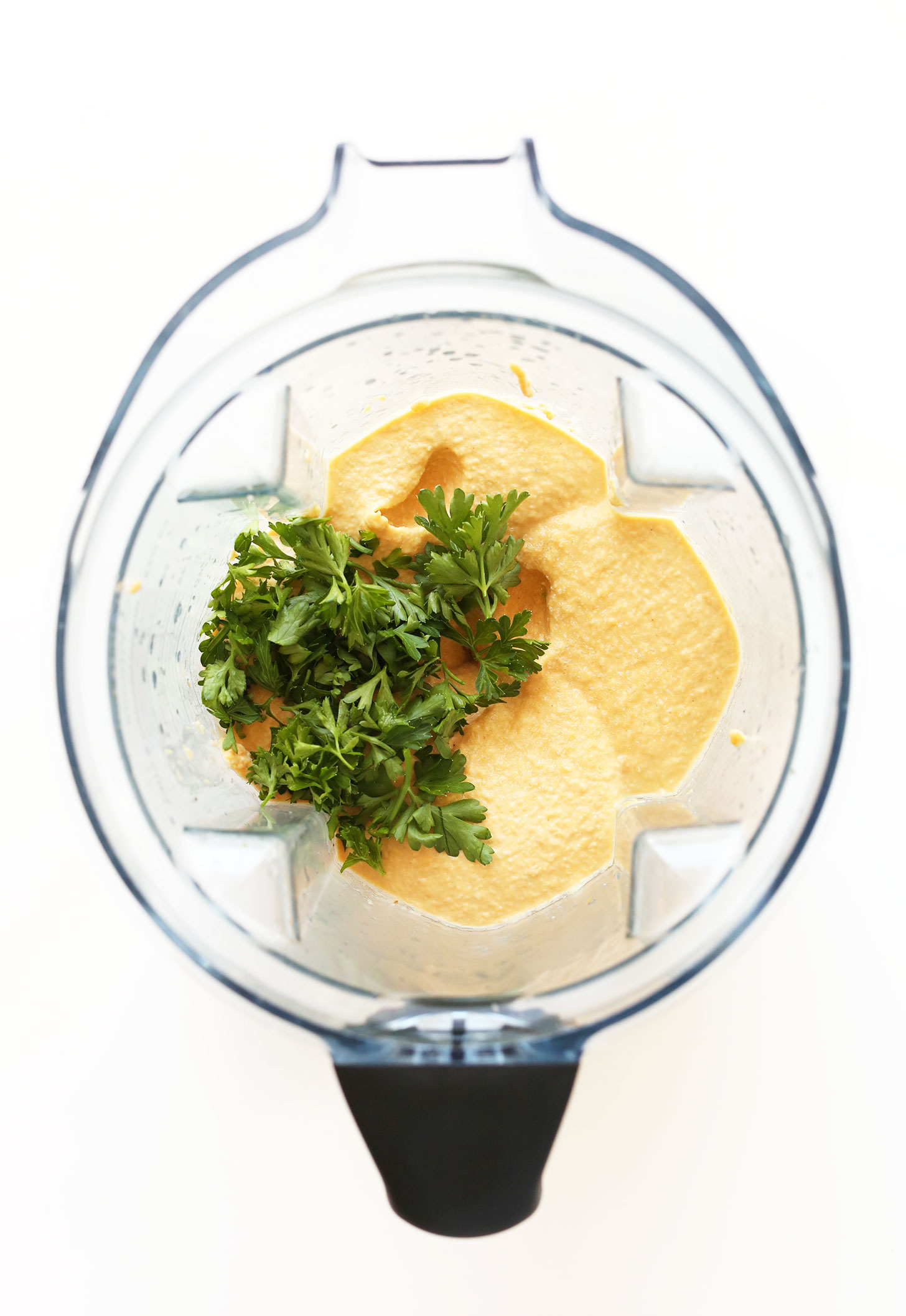 Blender with butternut squash hummus and fresh parsley