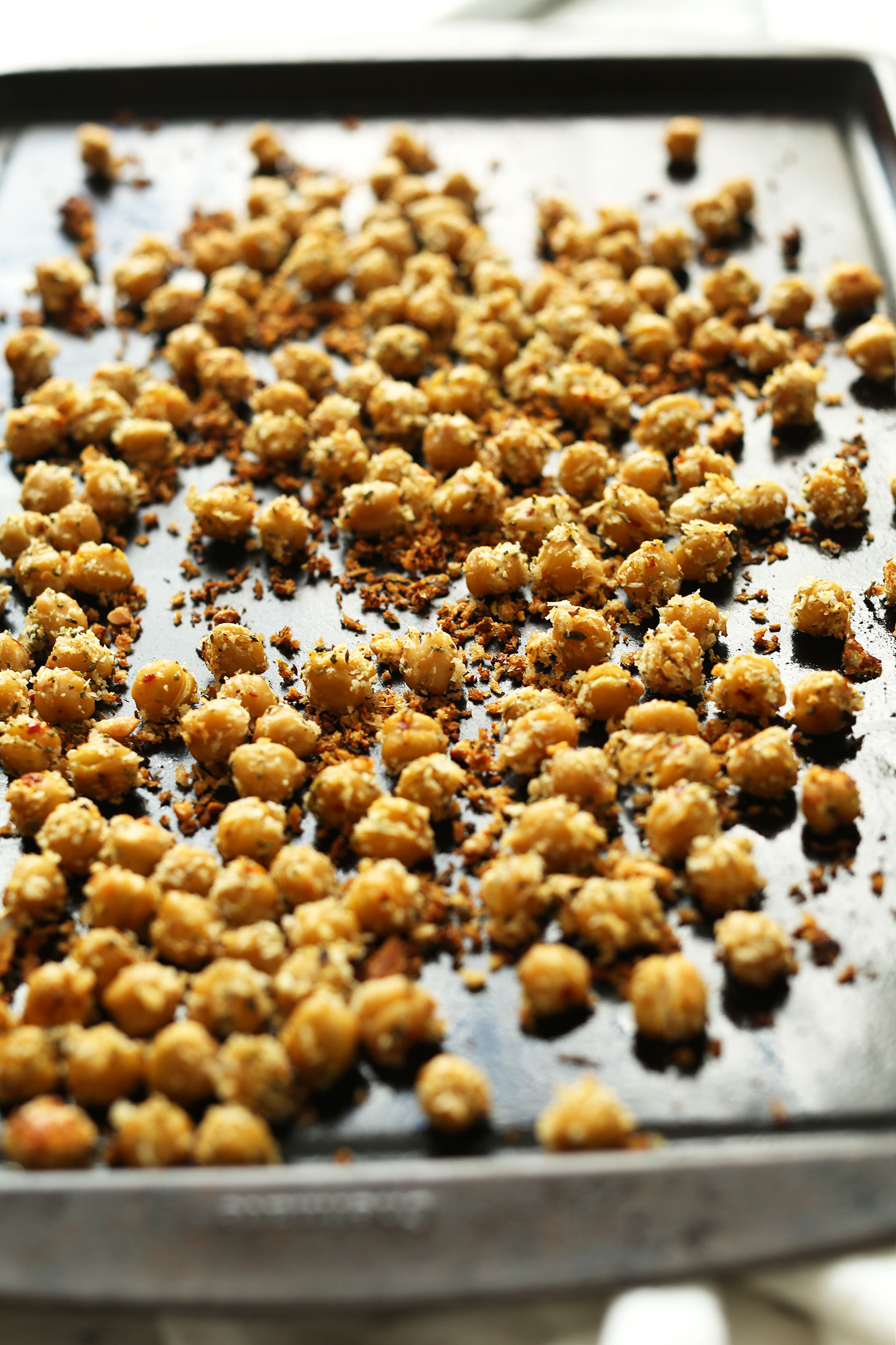 Baking sheet with freshly roasted chickpeas and spices for making a healthy plant-based dinner