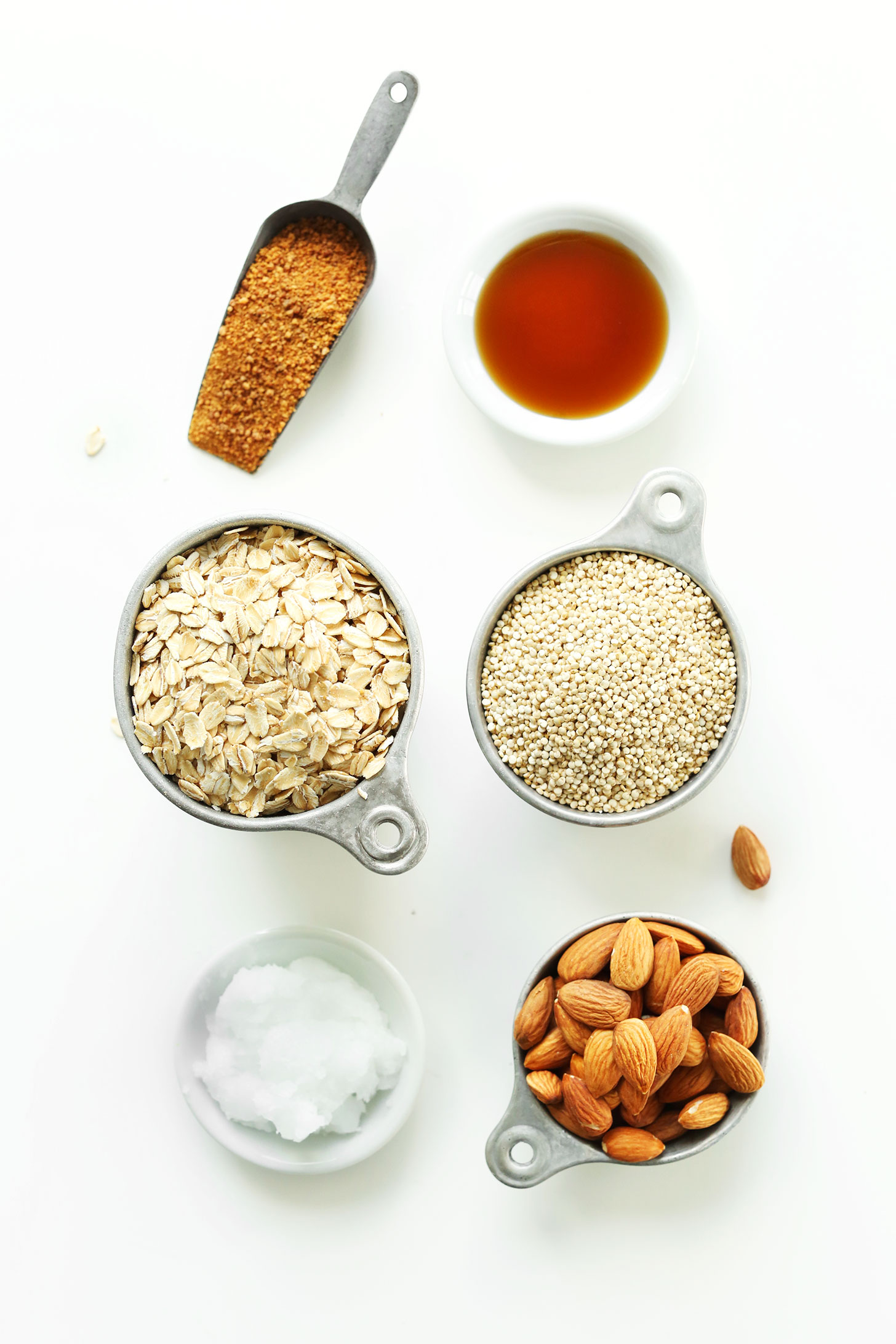 Coconut sugar, maple syrup, oats, quinoa, coconut oil, and almonds for making homemade vegan granola