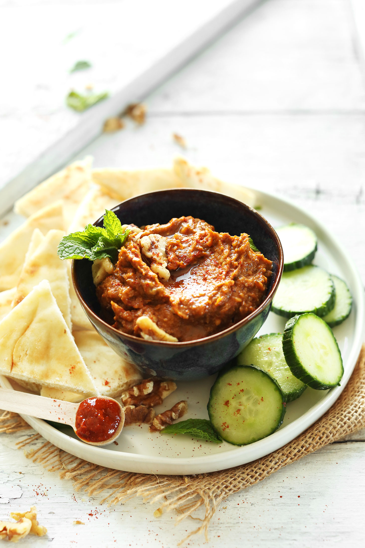Bowl of our Smoky Harissa Eggplant Dip with cucumbers and pita bread for dipping