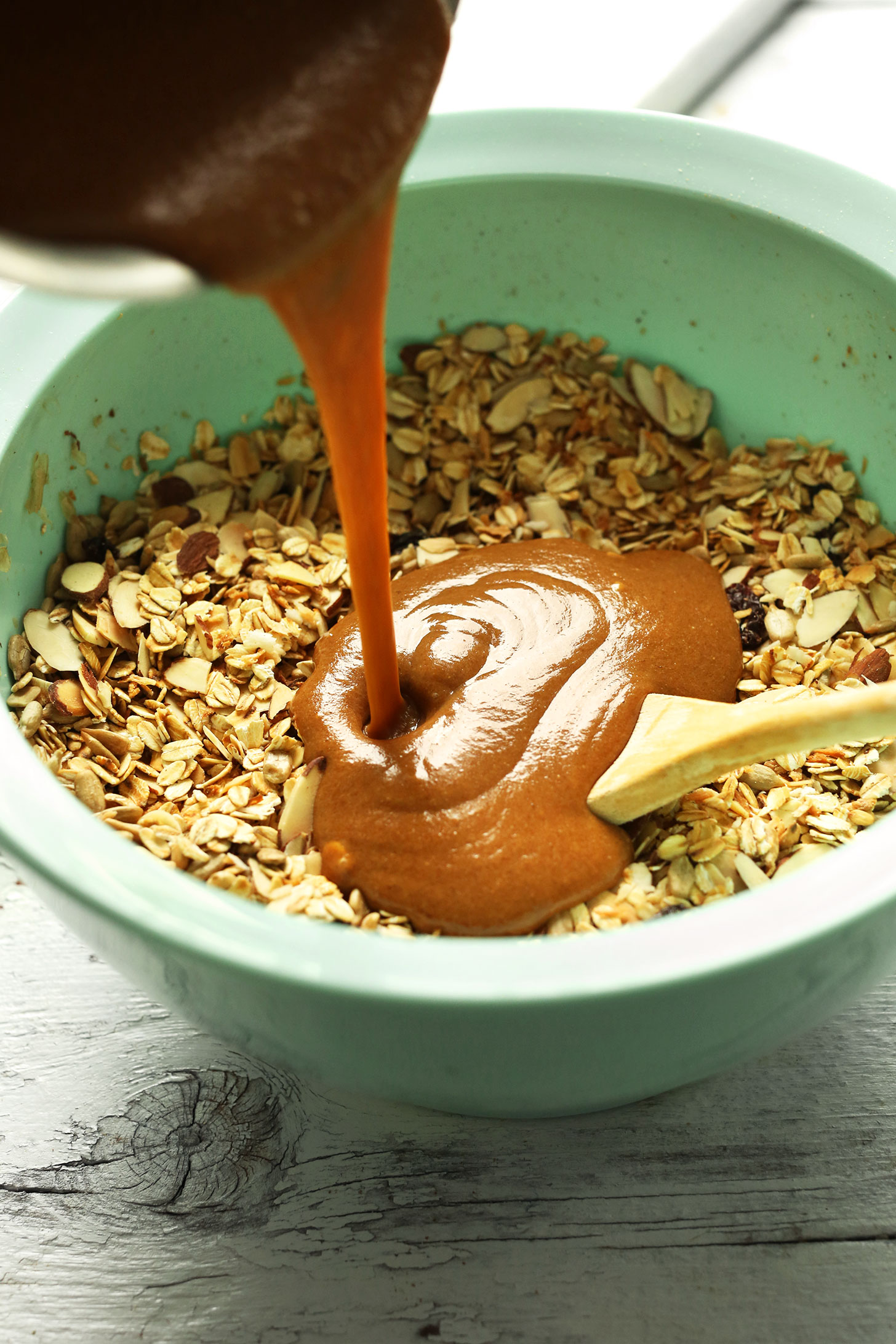 Pouring wet ingredients into dry for the best homemade gluten-free Peanut Butter Granola Bars