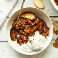 Bowl with a serving of the best Vegan Apple Crisp with a Pecan-Oat Topping