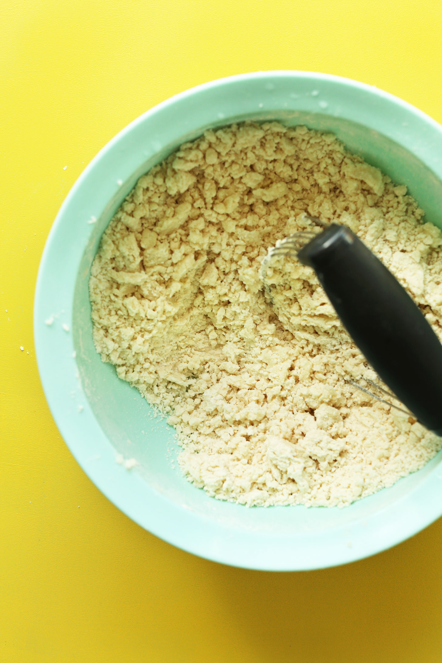 Using a pastry cutter to cut coconut oil into other crust ingredients