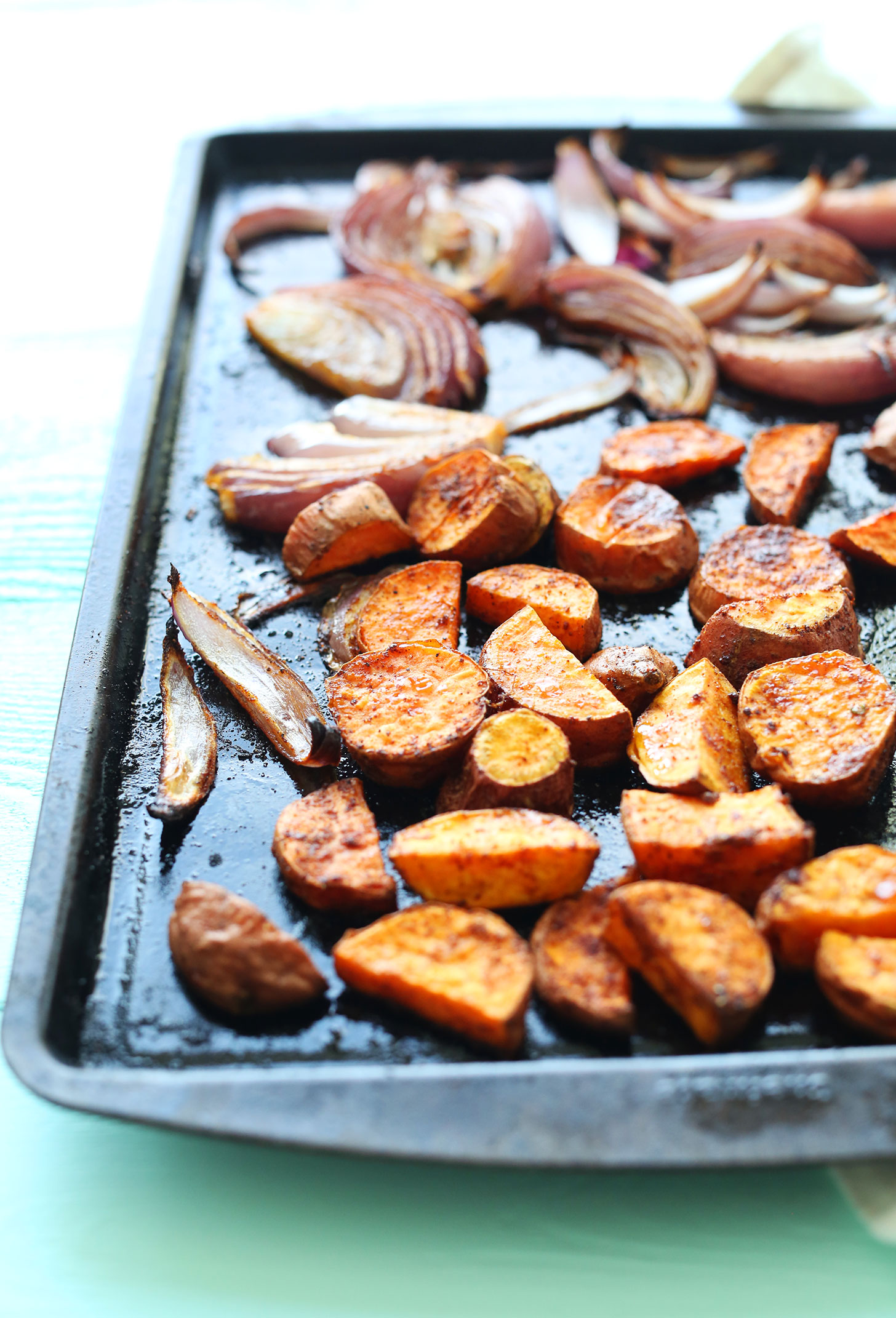 Baking sheet with roasted red onion and sweet potatoes for making a healthy tofu breakfast scramble