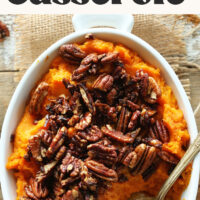 Overhead photo of a dish of butternut squash sweet potato casserole topped with candied pecans