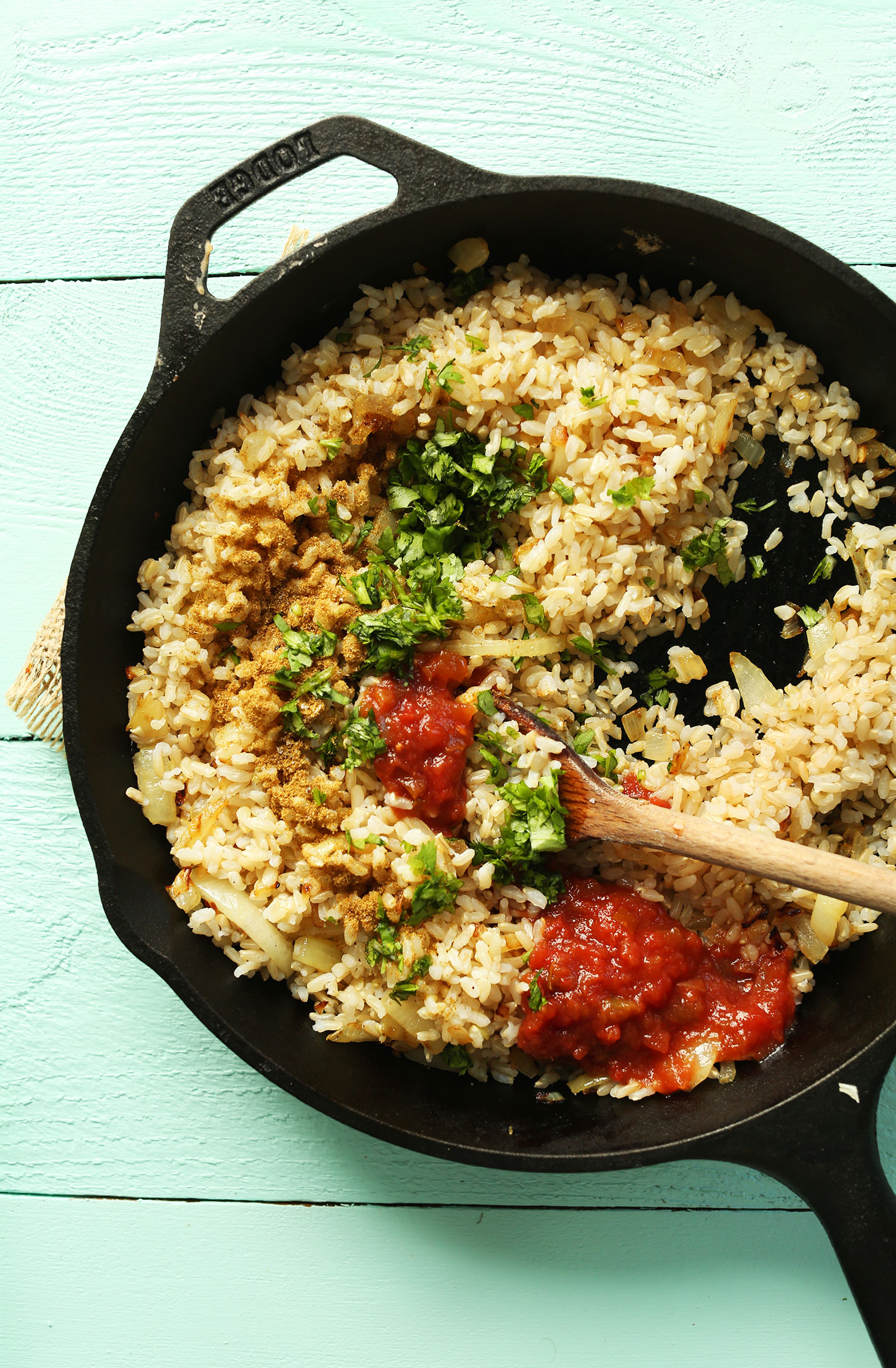 Mixing rice and seasonings in a cast-iron skillet