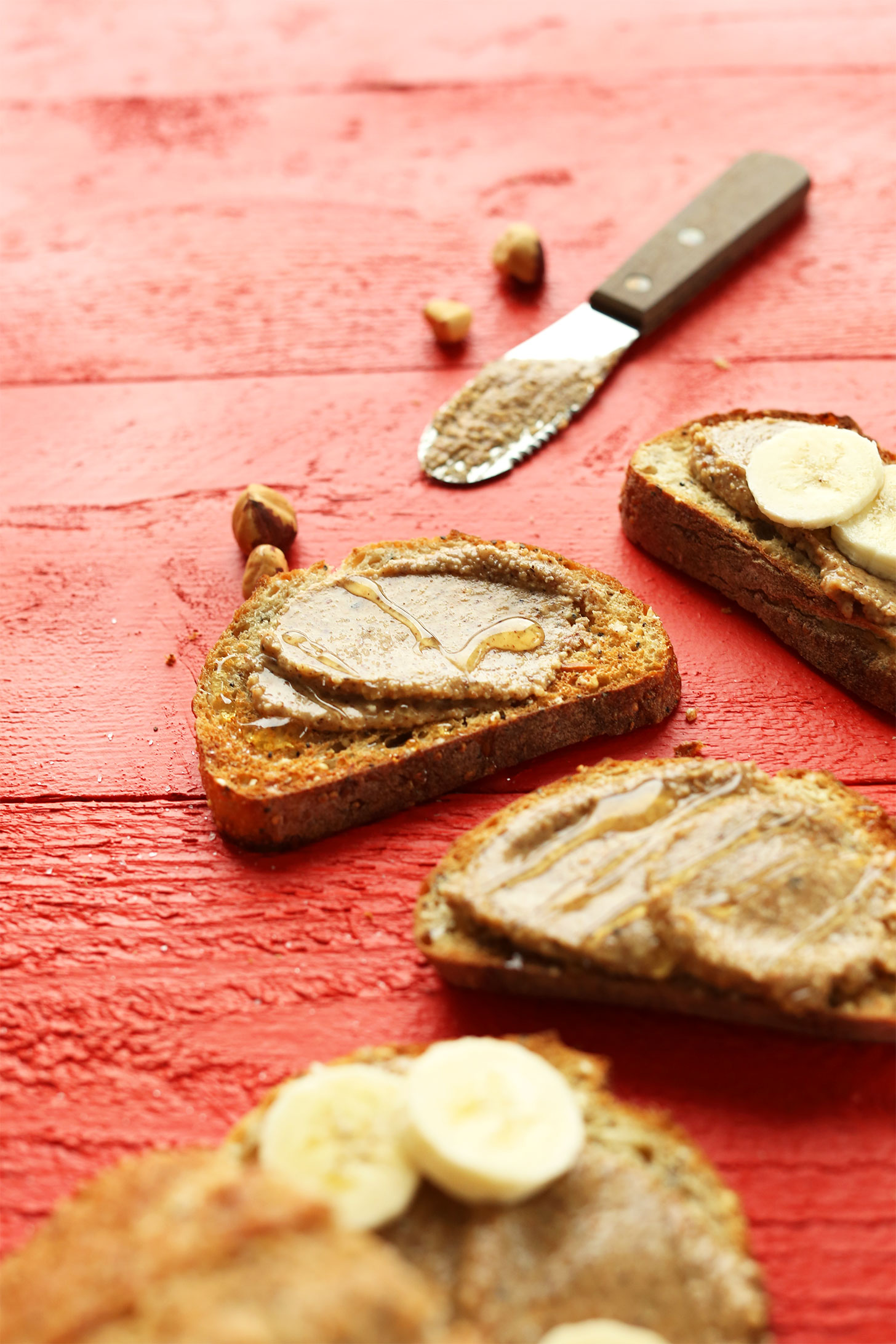 Spreading Cinnamon Hazelnut Butter onto gluten-free toast for a delicious vegan snack
