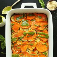 Baking pan filled with homemade Sweet Potato Lasagna drizzled with basil pesto