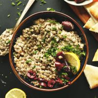 Bowl of Mediterranean Lentil Dip topped with kalamata olives and freshly chopped parsley
