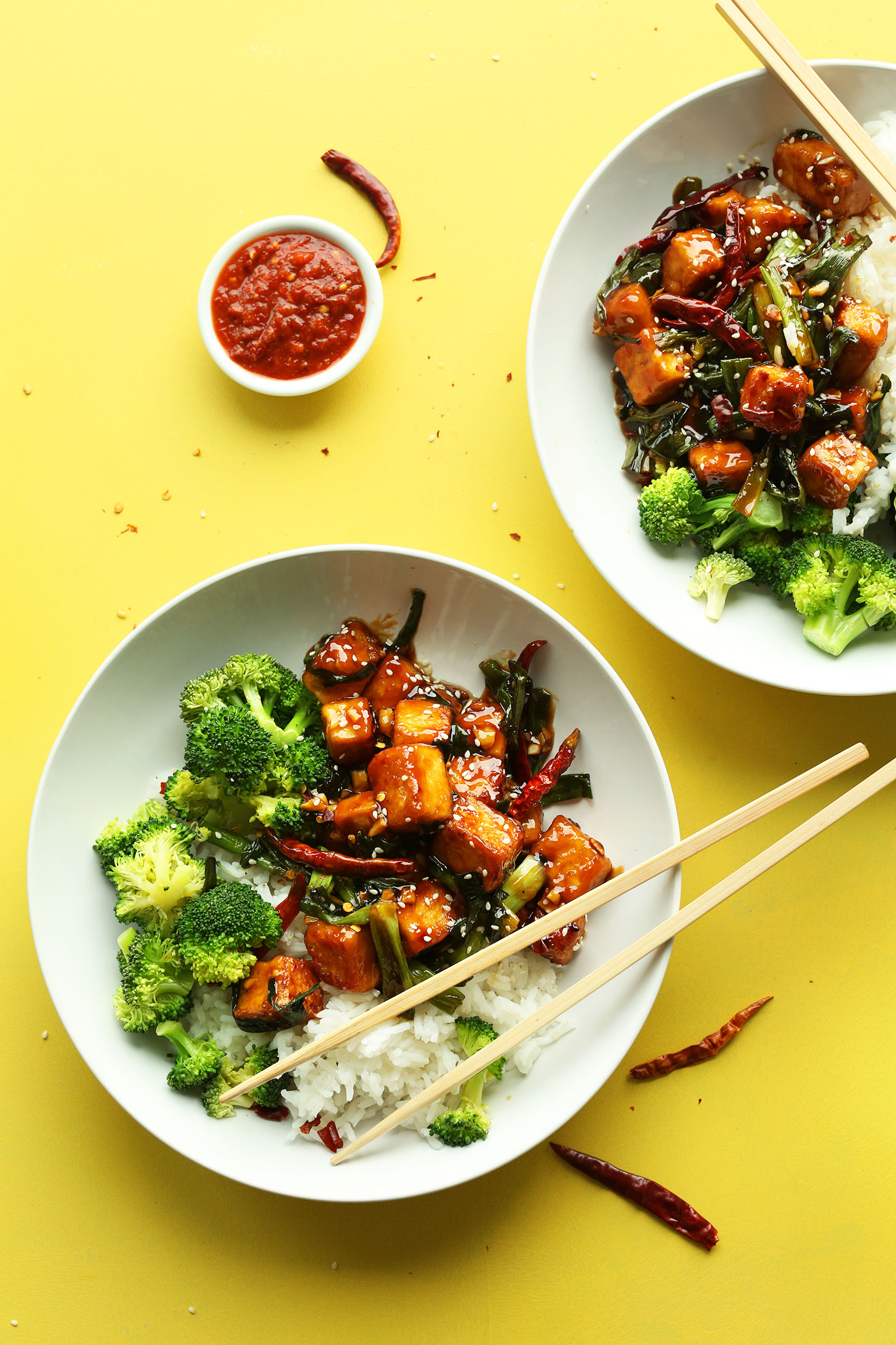Dinner bowls filled with our General Tso's Tofu recipe alongside broccoli and rice