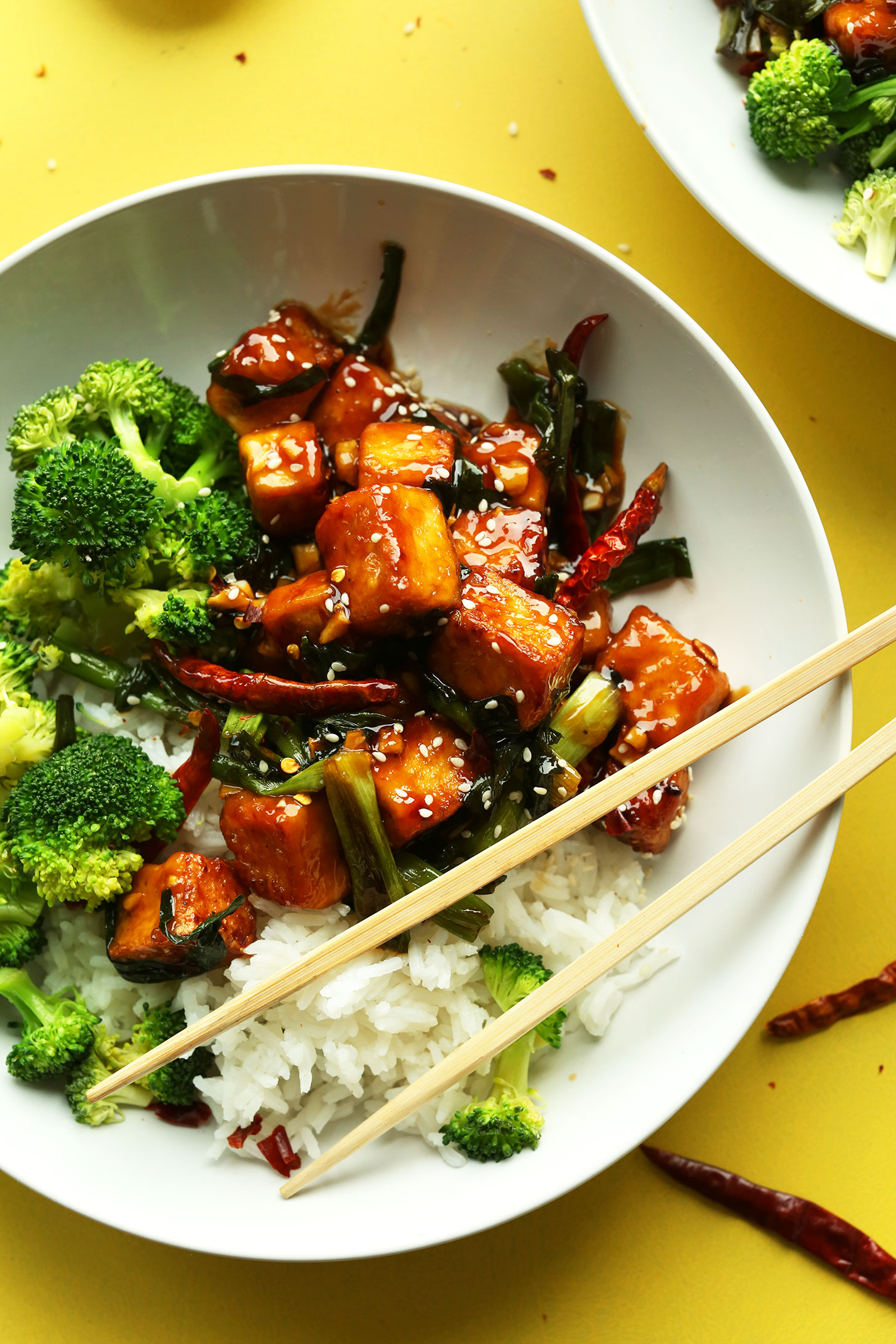Big bowl of our General Tso's Tofu recipe alongside rice and broccoli for a protein-packed vegan meal