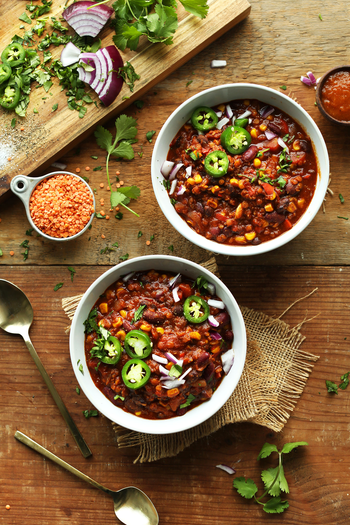 Bowls of Lentil Chili topped with red onion and jalapeño