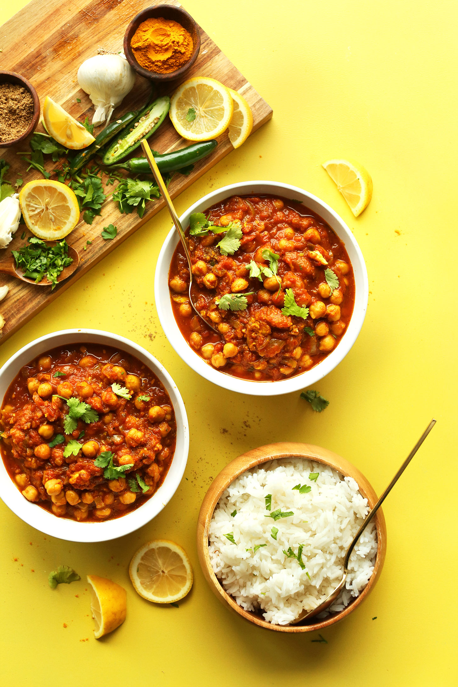 Bowls of our homemade gluten-free vegan Chana Masala with a bowl of rice