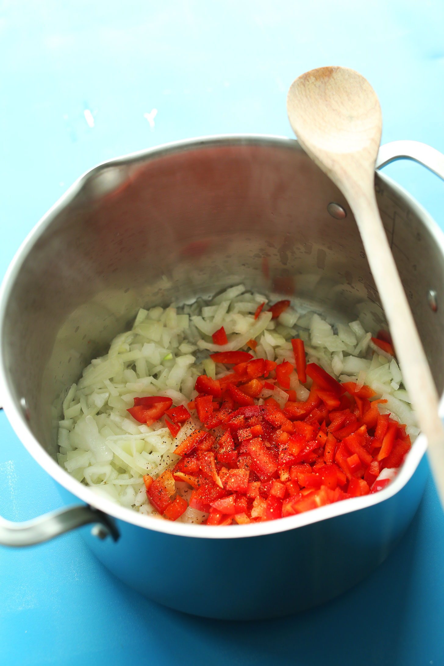 Sautéing red bell pepper and onions in a large soup pot for 1-pot vegan chili