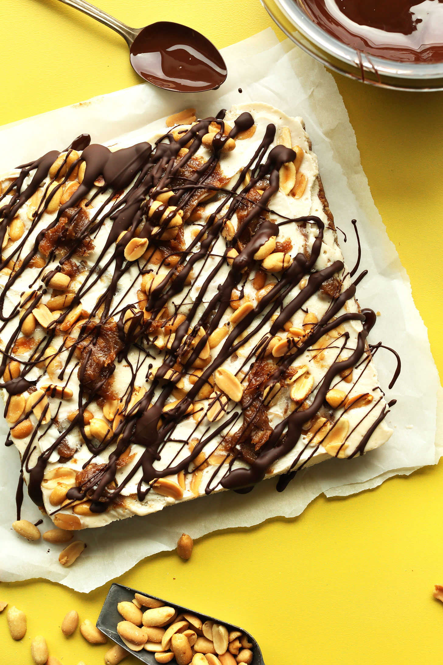 9 by 9 inch square gluten-free vegan snickers cheesecake drizzled with chocolate sauce