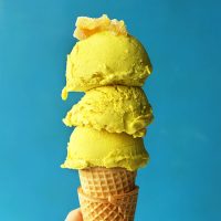 Triple scooped Golden Milk Ice Cream on a stack of sugar cones