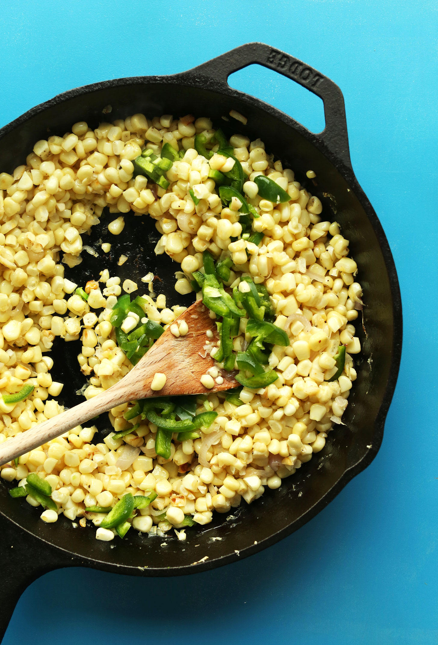 Cooking corn and jalapenos in a cast-iron skillet for our Cheesy Vegan Corn Dip recipe
