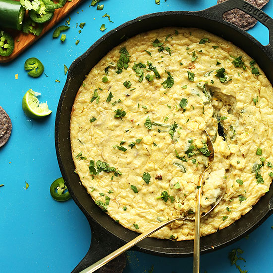 Two gold spoons in a skillet of Cheesy Jalapeno Corn Dip
