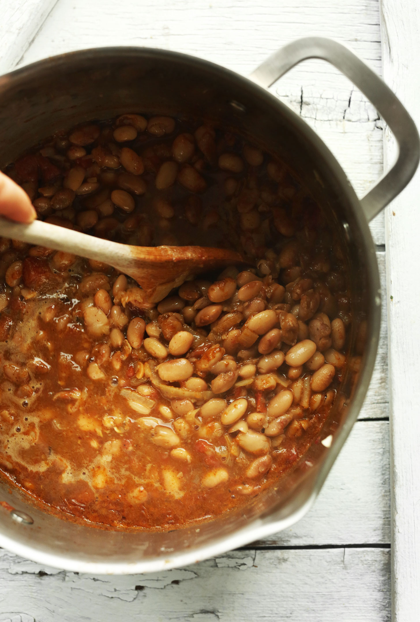 Stirring a big pot of beans made with our How to Cook Pinto Beans made from Scratch recipe