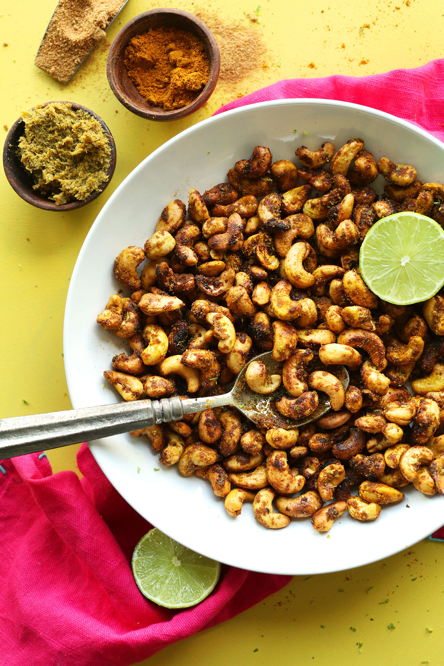 A spoon resting in a bowl of delicious Curry-Spiced Cashews