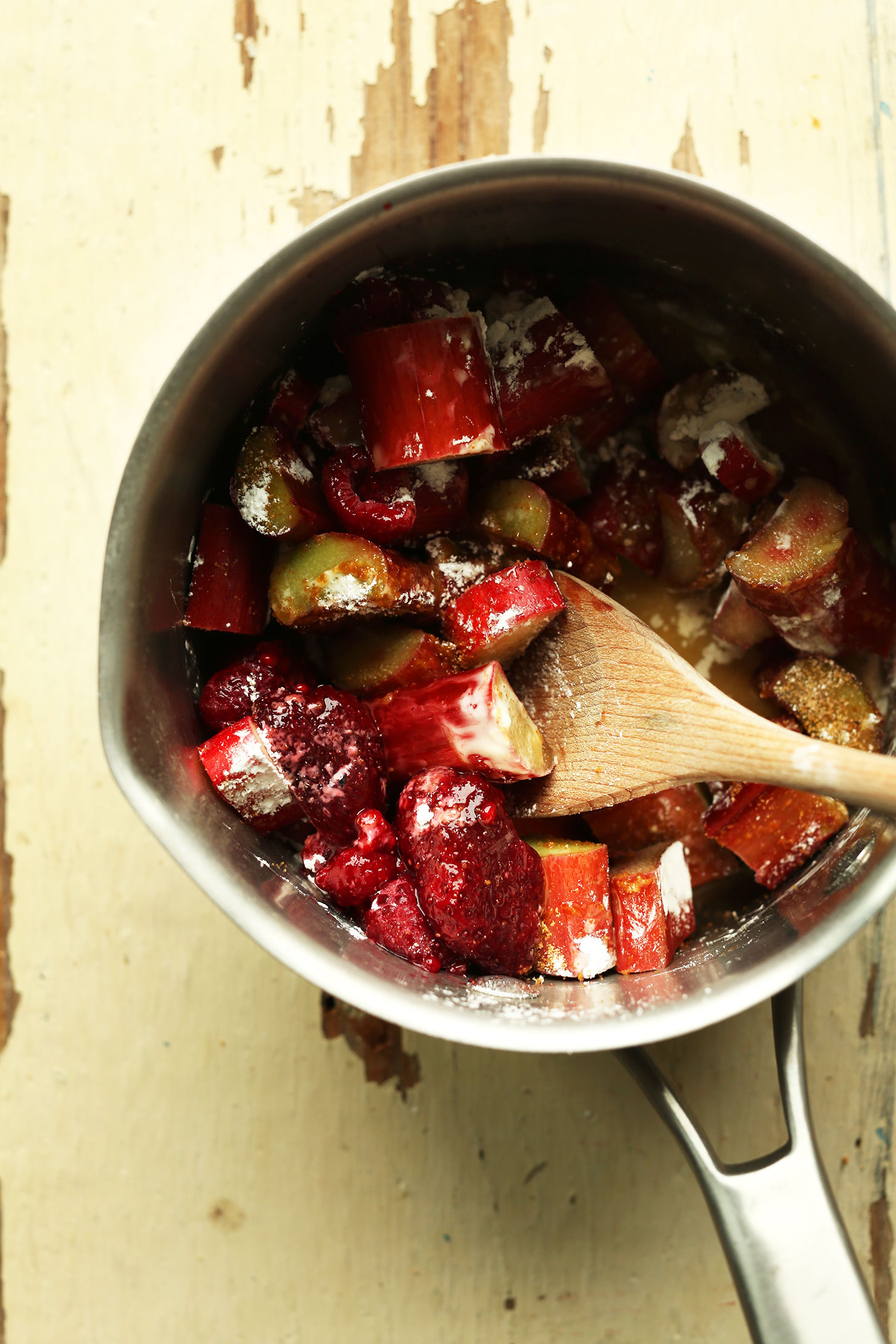 Stirring rhubarb and strawberries in a saucepan for our crumble bar filling