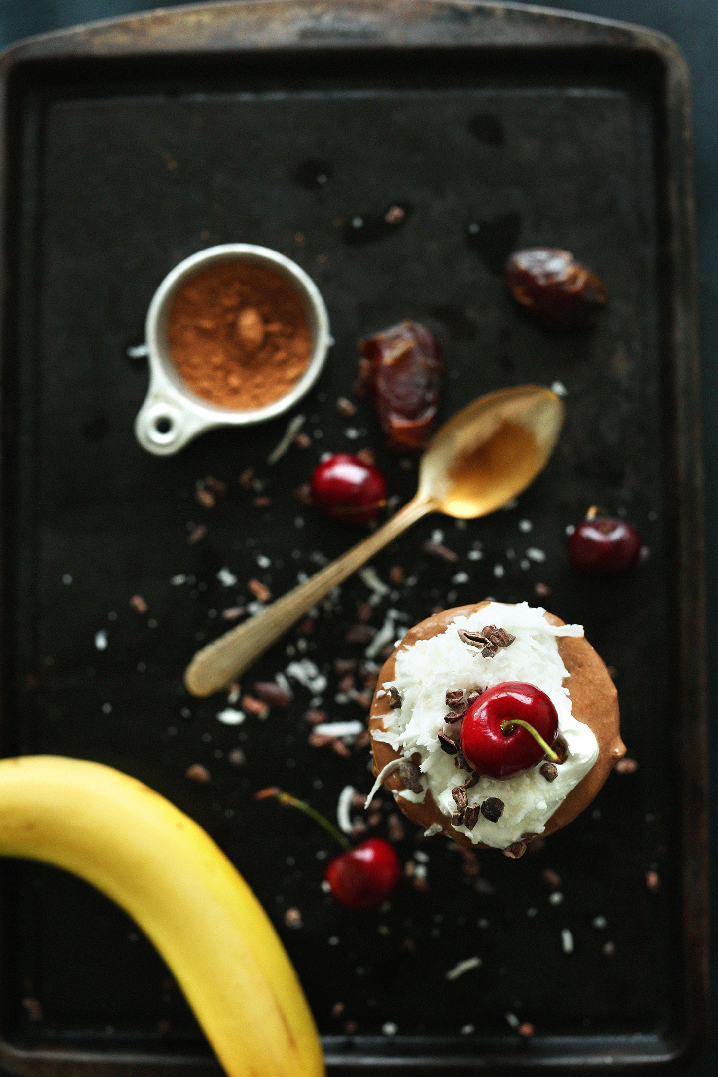 Top view of our Banana Split Smoothie showing a cherry and cacao nibs on top of coconut whip