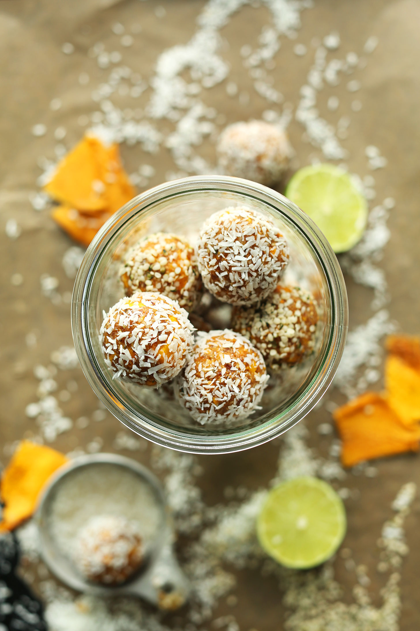 Jar of gluten-free vegan Dried Mango Energy Bites rolled in shredded coconut